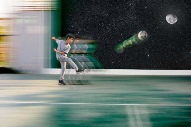 boy training soccer, kicking a ball hard in front of a wall with decoration of the sky and stars