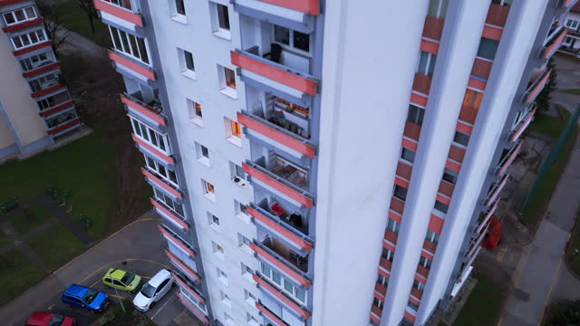 AERIAL Drone Moving Down of Residential Building and Cars Parked in Town