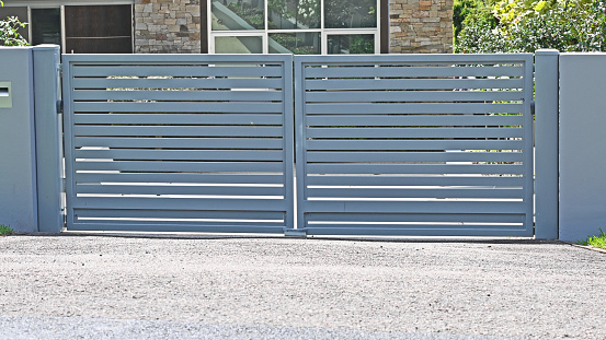 Grey metal front entrance gate with horizontal slats