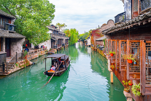 Jiaxing City, Zhejiang Province, China - November 17th 2019: Photo of Tourist Scenery of  Wuzhen  ancient town，river surround ancient houses and ship on the river in sunny day