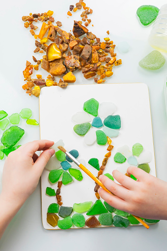 Sea glass is small polished pieces of broken bottles and other glass products collected on the beach and pieces of amber. A gift for a holiday on March 8, birthday, mother's day