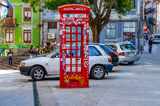 Woman tourist talking on the phone in British old red telephone booth. Gibraltar, United Kingdom
