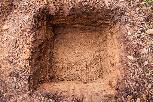 Hole in a soil, prepared for planting or construction, pit in a ground with shovel