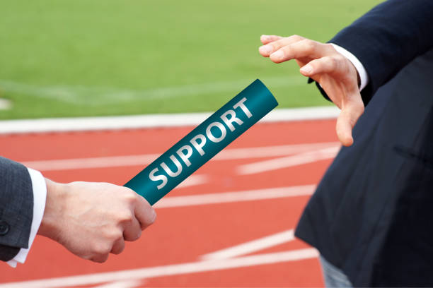 istock Businessman passing relay baton to another business person support help concept 2049802076