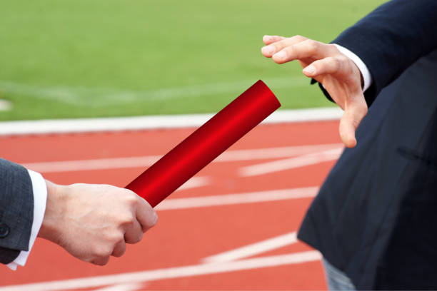 Male athlete legs standing on starting block ready to run at stadium track back view close up