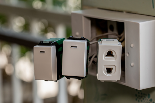 Electrical plugs and light switches in residences that are being repaired.