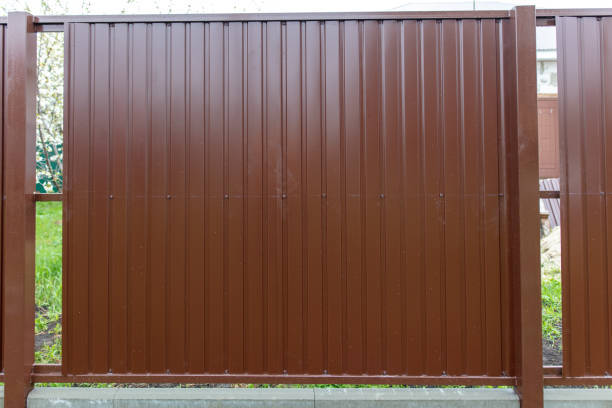 istock Workers install a metal profile fence 2049862671