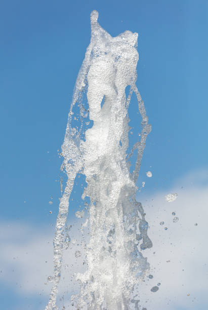 Fountain splashes against the blue sky. Background.