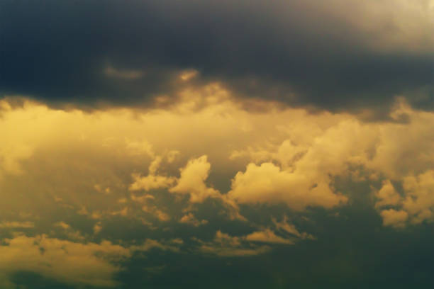 gloomy rain clouds with a yellow tint under the rays of the sun herald the beginning of the imminent onset of rain. prerequisites for weather change - the eye of the storm thunderstorm storm cloud imagens e fotografias de stock