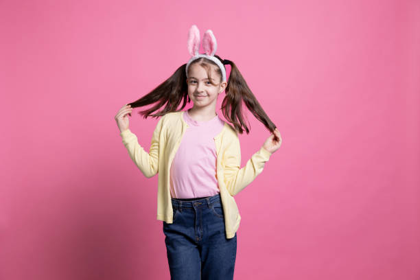 istock Cute small girl posing in studio with bunny ears and pigtails 2049902259