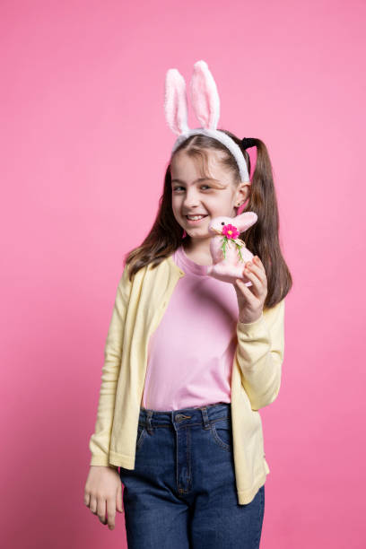 istock Adorable small kid holding a fluffy pink rabbit toy on camera 2049910629