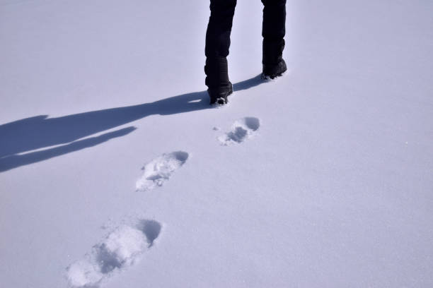istock man's feet walking on snow 2049915353