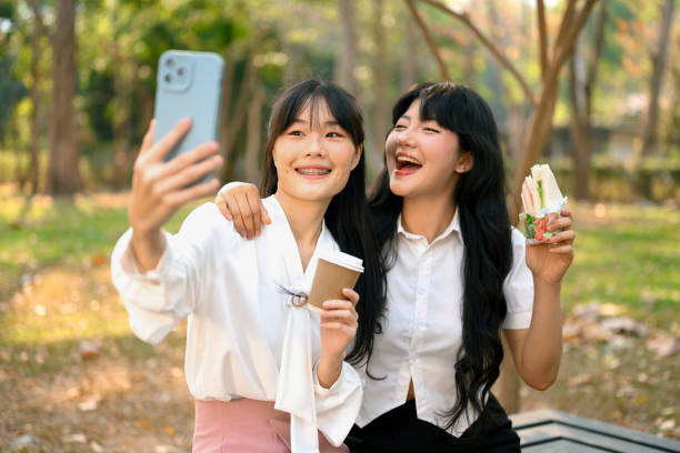 istock Two happy laughing colleagues taking a selfie in the park during break 2049916938