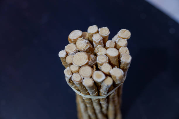 A bunch of miswak stems on a black table.
