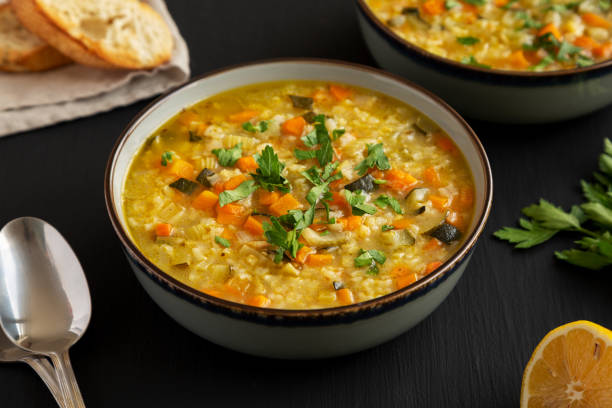 istock Homemade fresh lemon rice soup in a bowl on a black surface, side view. 2049936556