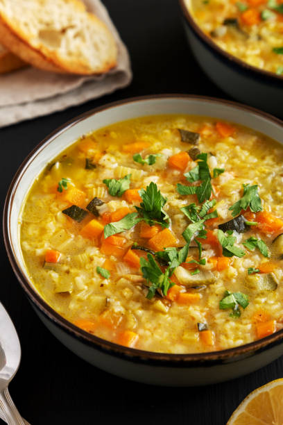 istock Homemade fresh lemon rice soup in a bowl on a black surface, side view. 2049937076