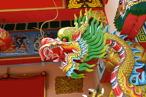 Chinese Dragon Statue on roof of temple with blue sky background