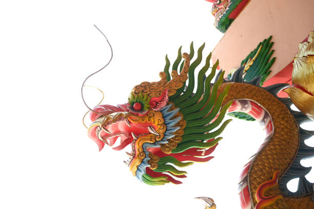 This image showcases an exquisitely detailed wooden carving of a dragon, a symbol of power, strength, and good fortune in many cultures. The dragon is depicted with a fierce expression, its body coiled in a dynamic pose that conveys movement and energy. The carving is rich in texture, with each scale and feather-like appendage meticulously rendered to create a lifelike representation. The warm, golden-brown tones of the wood enhance the depth and dimensionality of the carving, highlighting the artist's skill in manipulating the material to bring the dragon to life. This piece likely serves both a decorative and a symbolic purpose, embodying cultural heritage and the reverence for mythical creatures. It may be part of a larger architectural structure or a standalone piece intended for contemplation and admiration of the artisan's work.