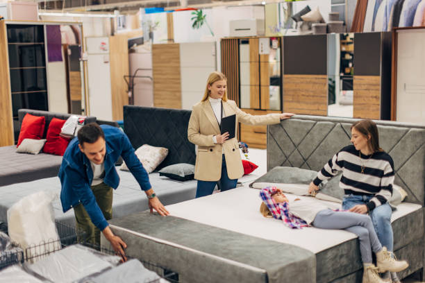 istock A smiling saleswoman is holding a digital tablet while helping customers choose a comfortable bed for their new bedroom 2049957270