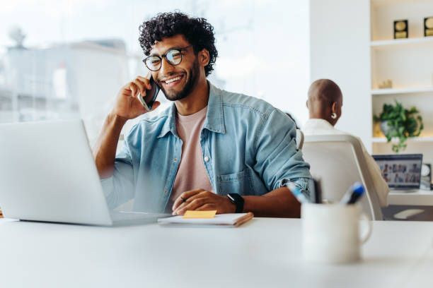 istock Happy young entrepreneur speaking on smartphone at modern office workplace 2049962306