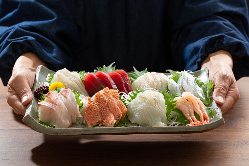 Cook with sashimi platter, sashimi, japanese food, table, meal