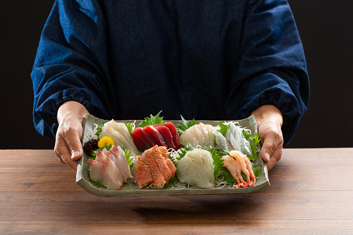 Cook with sashimi platter, sashimi, japanese food, table, meal