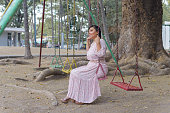 Woman swinging in an outdoor park.