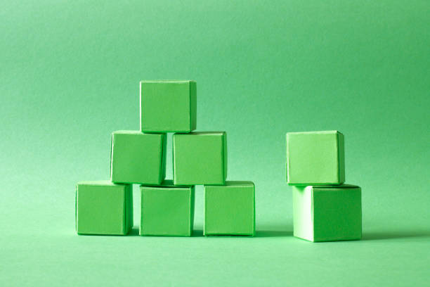 istock Green Cubes Organized in a Pyramid Formation on Uniform Teal Green Background 2049972552