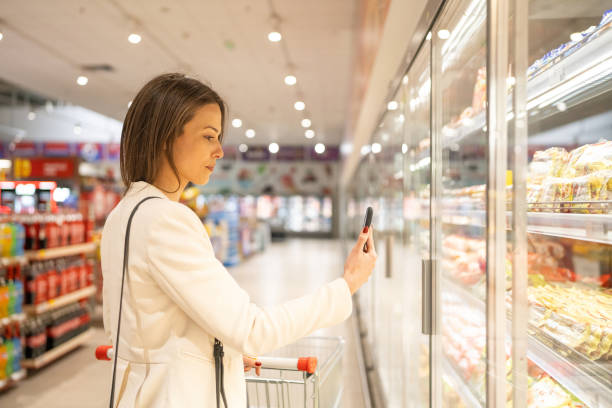 istock Woman using phone at supermarket 2049982667