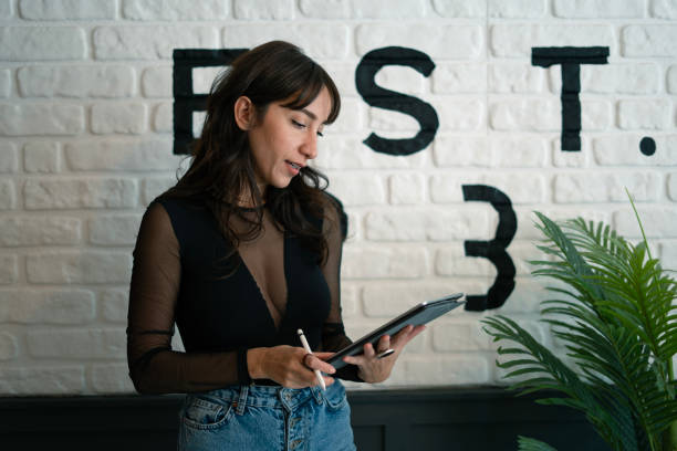 istock Beautiful businesswoman using digital tablet in cafe 2049991251