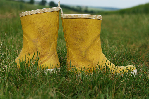 A farmer stands in his parched pasture with his green rubber boots. Rising temperatures, longer heat periods and too little rain - the fields in Germany are dry like never before.
