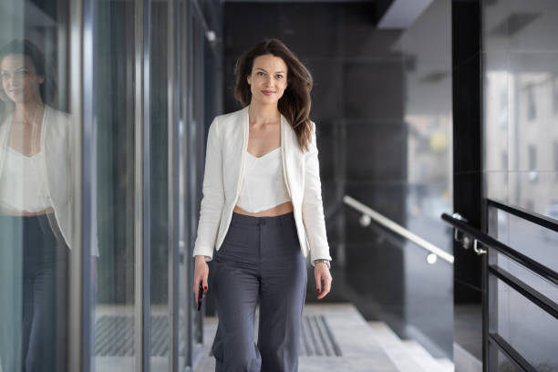 istock Stylish woman walking through glassy corridor 2049996508
