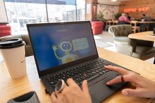 Close-up Woman hand using chatbot with laptop in cafe