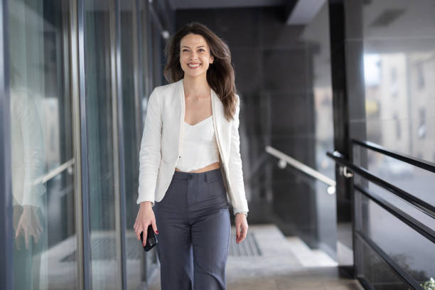 istock Happy young woman walking through glassy corridor 2049999714