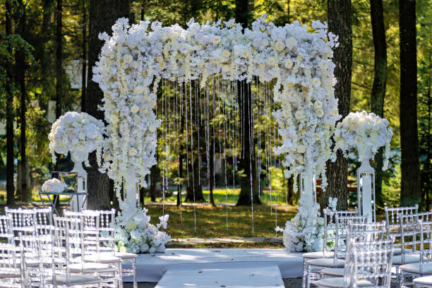 istock Wedding ceremony setup with white flowers and white draping on the aisle 2050019809