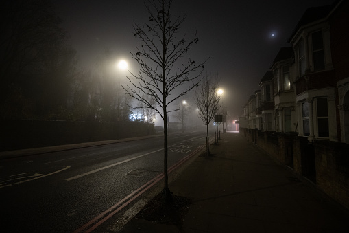 Empty street at night in the fog in north London,