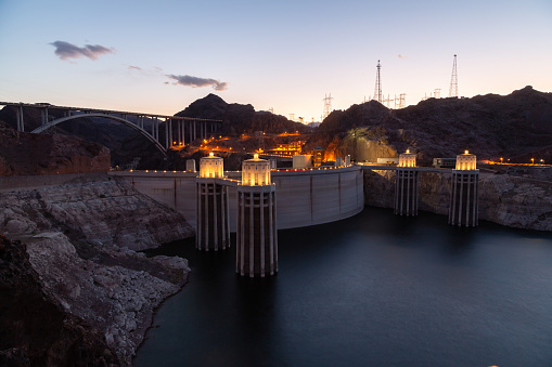 Hoover Dam at sunset in the evening with illuminations without people. Hoover dam, view point. Hoover dam and Lake Mead in Las Vegas area. Large Comstock Intake Towers At Hoover Dam.