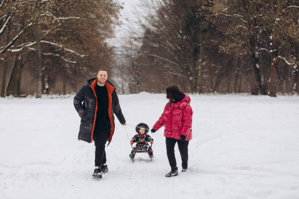 istock Happy young family walks through the winter forest holding hands. 2050101281
