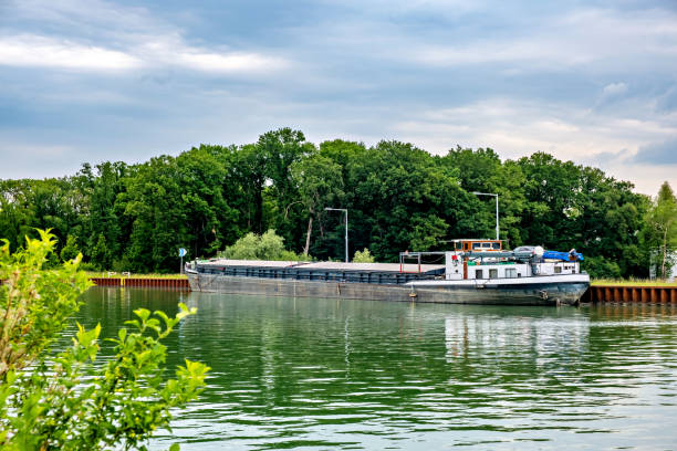 istock Large cargo ship sails along the river against the backdrop of green trees 2050110247