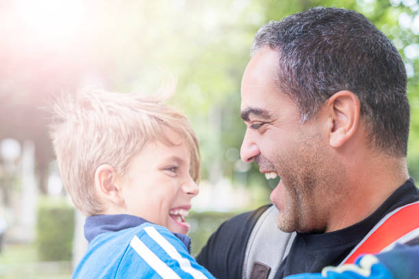Father and his little son having fun in summer park