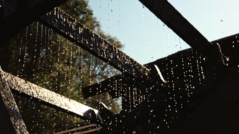 Low Angle View of Wooden Watermill Turning while Generating Hydroelectricity during Sunny Day