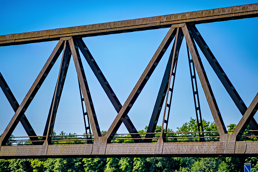 Large blue steel bridge with X-shaped support beams.