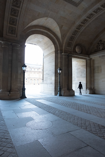 Paris, France – February 26, 2024: A person passing through the archway of the Louvre Museum