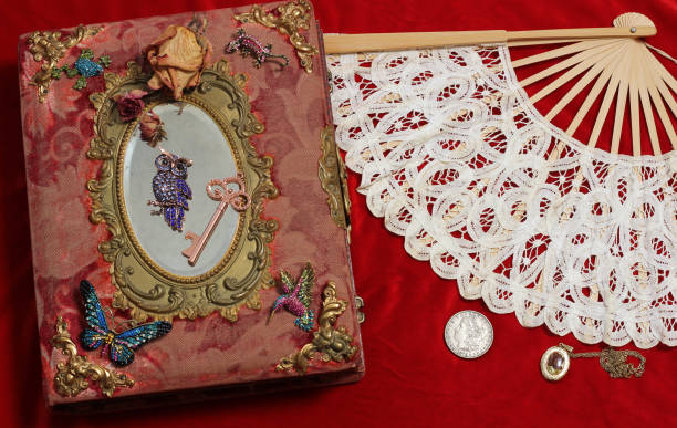 istock Vintage book with mirror and a fan on red backdrop 2050186140