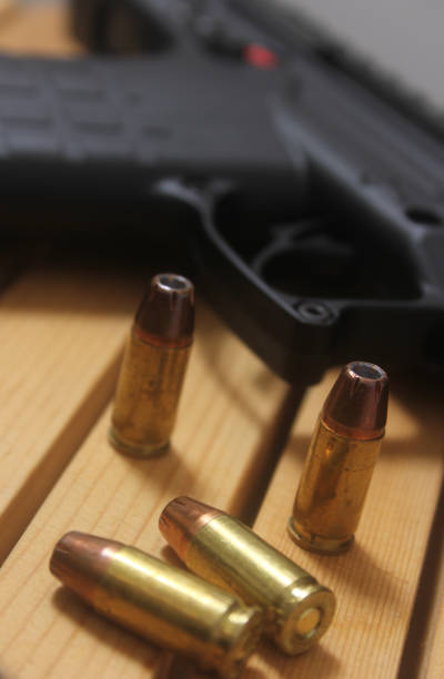 istock Gun with bullets on a wooden table 2050186144