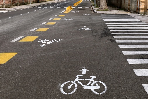 Two way bike lane along the urban street with painted signs, directiona arrows and crosswalks. Background for copy space.