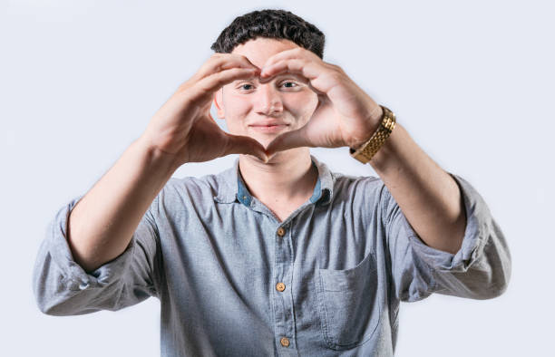 istock Handsome young man making heart shape with hands isolated. Smiling latin man making heart shape with hands 2050209047