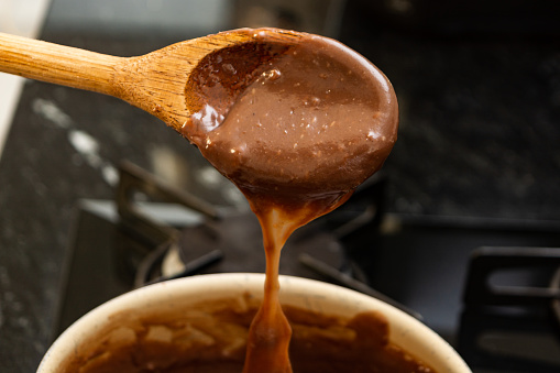 A close-up of a wooden spoon used in making homemade chocolate brigadeiro