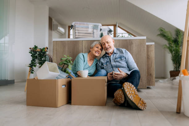 Senior couple sitting on a floor while renovating house