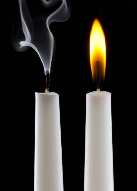 Three candles in candlestick and fireplace in background